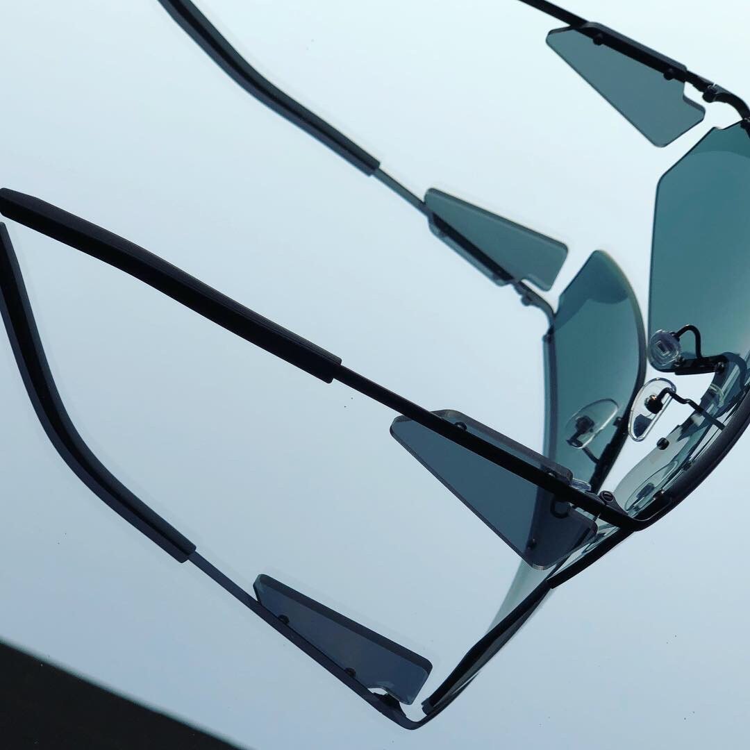 Macro close-up detail shot of custom OEM aviator sunglasses featuring a black frame and blue grey tinted lenses, manufactured by Concept Eyewear in Vietnam, China, and Asia.