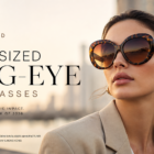 Oversized bug-eye sunglasses on a confident model in an urban 2026 setting, with warm gradient tinted lenses and tortoiseshell frames.