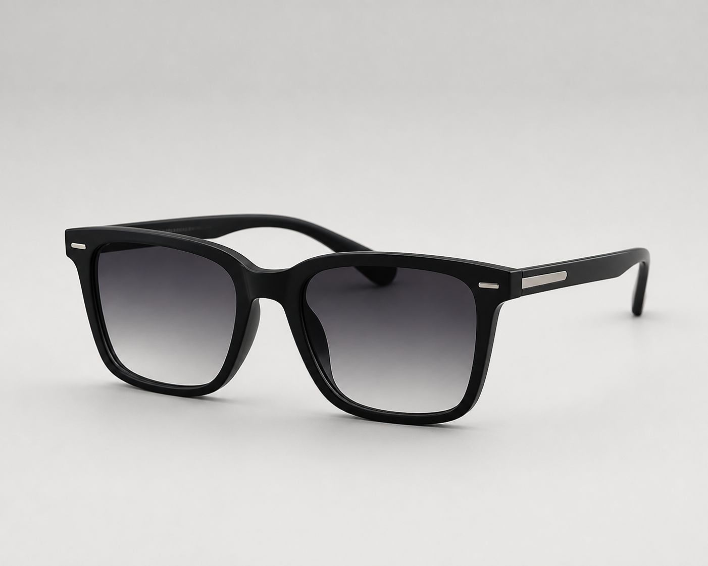 Black square-framed sunglasses with gradient gray lenses on a light gray background.