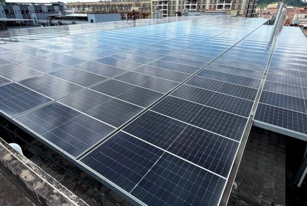 Solar panels installed across a commercial rooftop in an urban area.