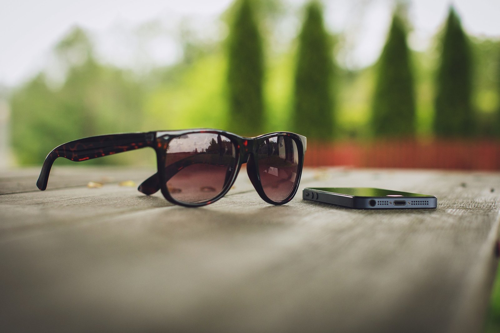 Eyewear assortment merchandising calendar: unbranded tortoiseshell sunglasses on outdoor table for seasonal sun wave timing, no brand marks