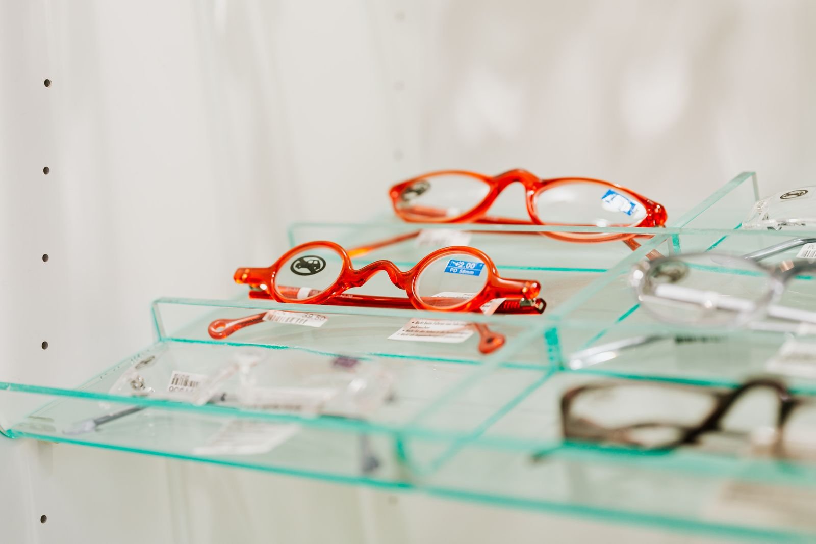 Eyewear sell-through rate featured – Concept Eyewear Eyewear sell-through rate: unbranded optical frames on glass assortment shelf for inventory velocity readout, no brand marks
