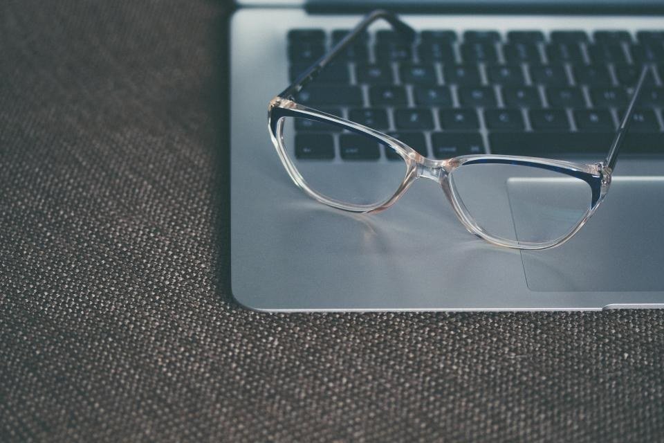 Unbranded crystal and navy two-tone optical frame on a laptop, showing injection frame finishes for Japanese brands