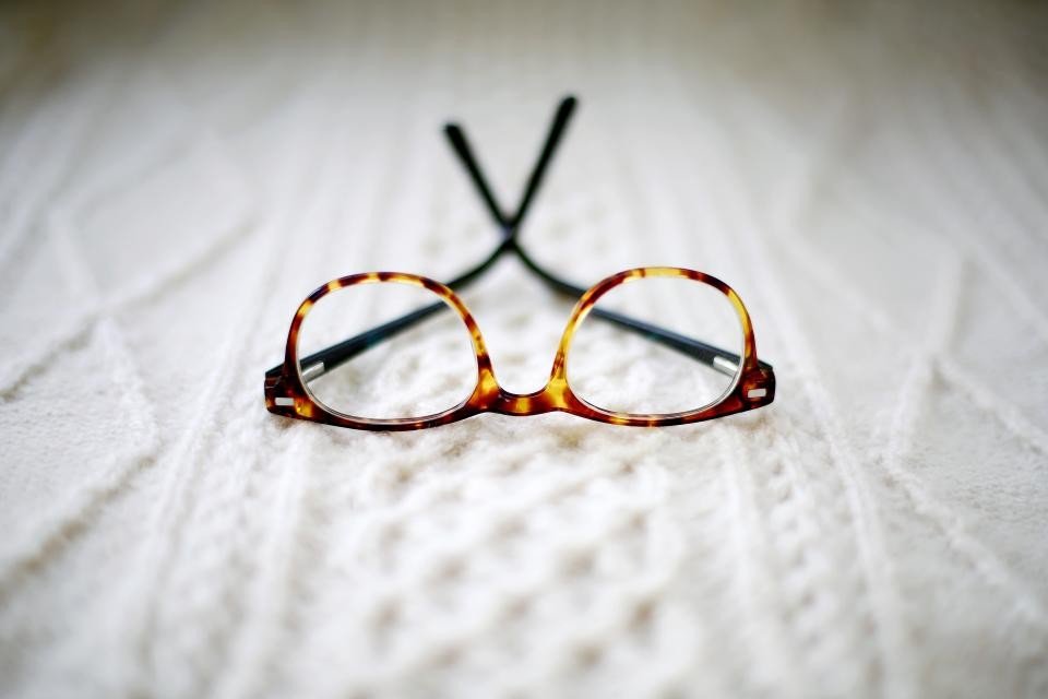 Unbranded tortoise injection frame on white knit, showing Japan injection eyewear made in Vietnam