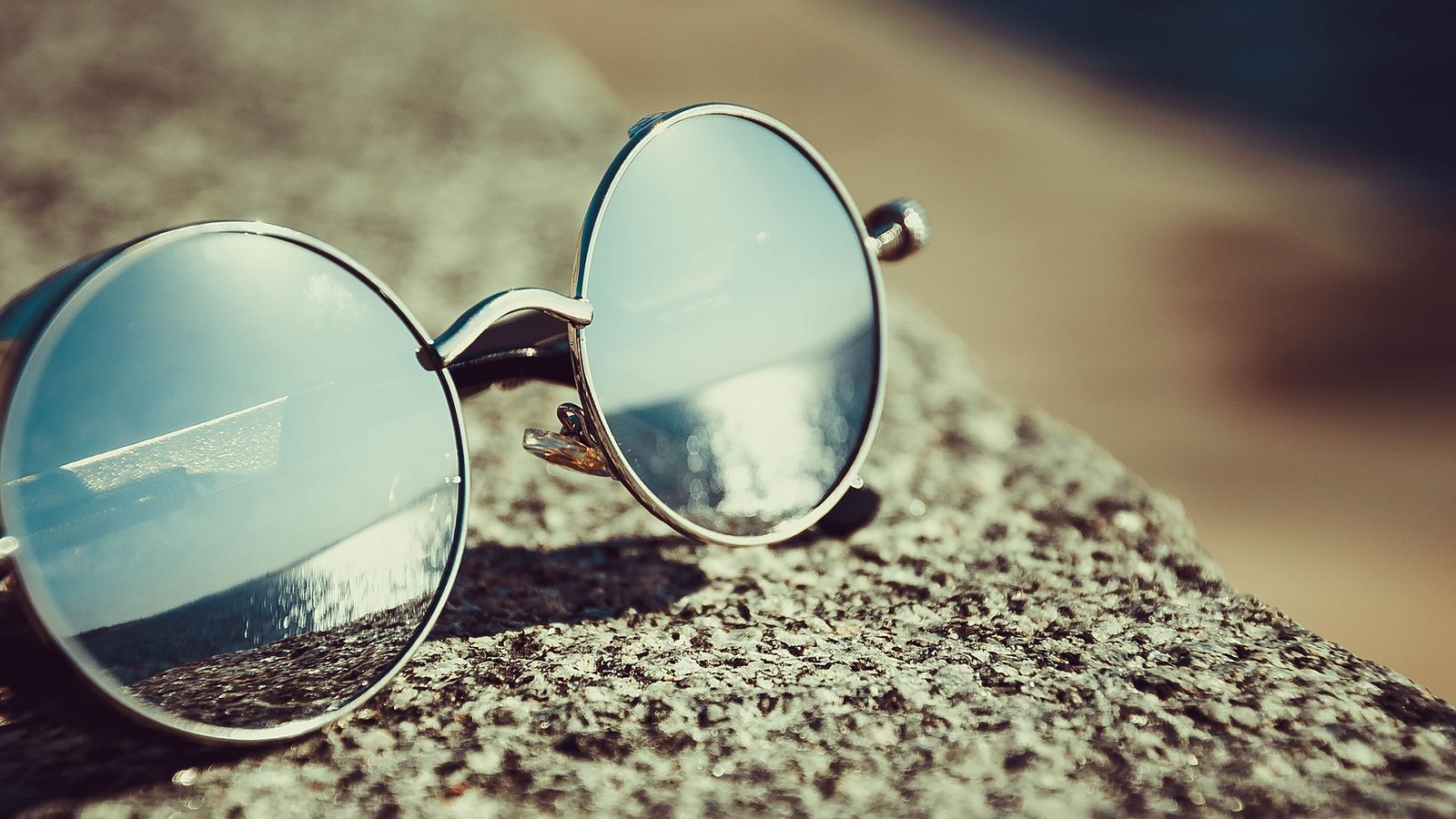 Fashion-first open-ear Bluetooth glasses with round metal frames in a lifestyle editorial still